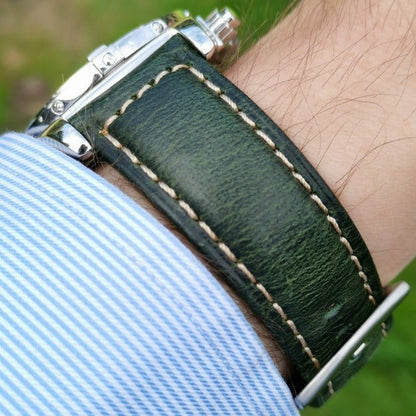 Wrist shot of the berlin green leather watch strap. Image taken on a males wrist with a blue and white shirt sleeve.