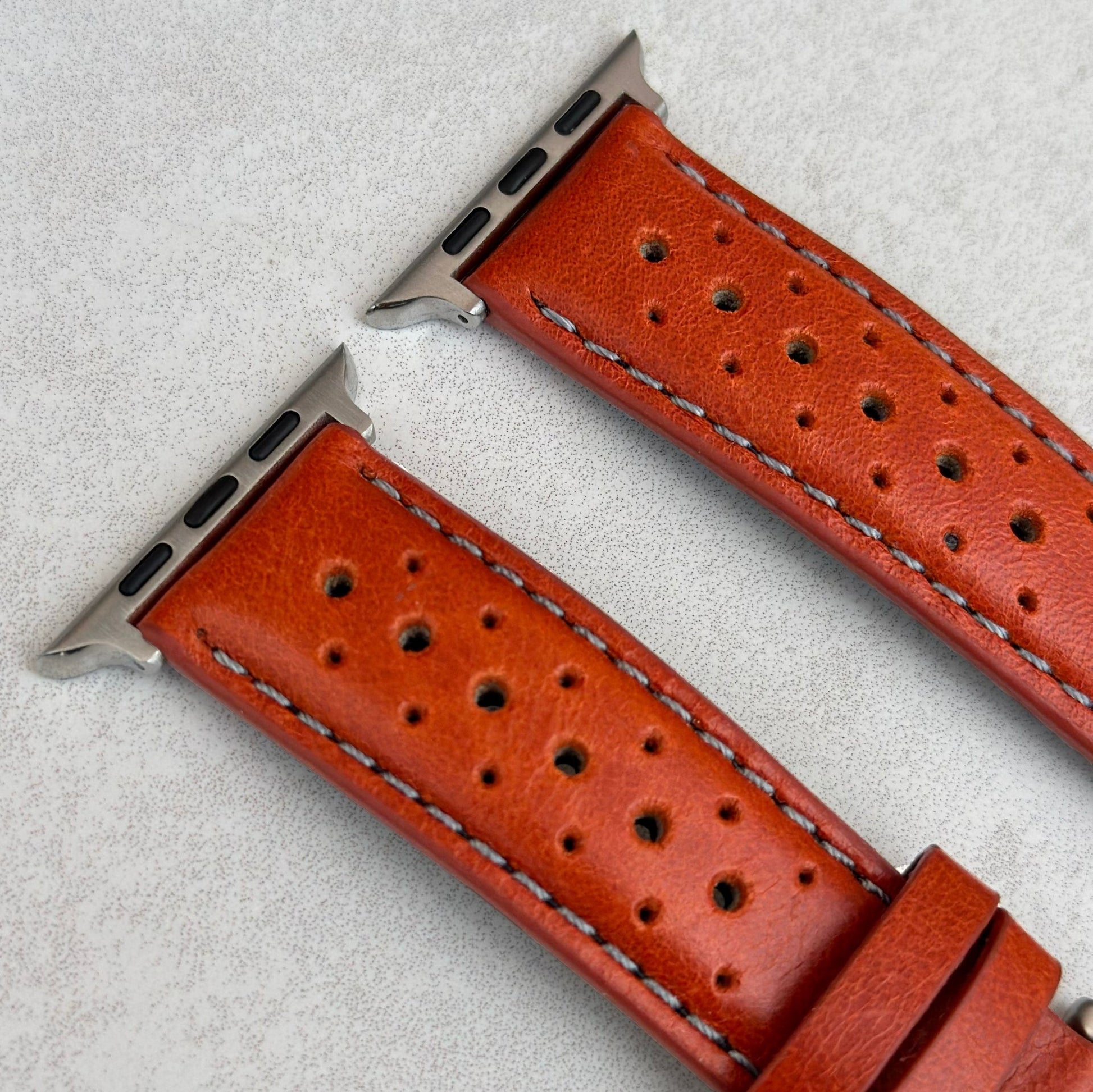 Top of the Orange Perforated leather Apple Watch strap. Contrast grey stitching. Watch And Strap